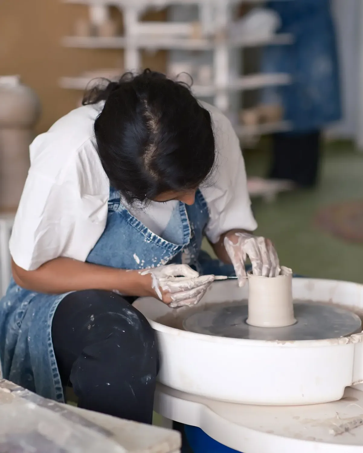 Student working on a ceramic piece during the Dharamkot Studio pottery school course.