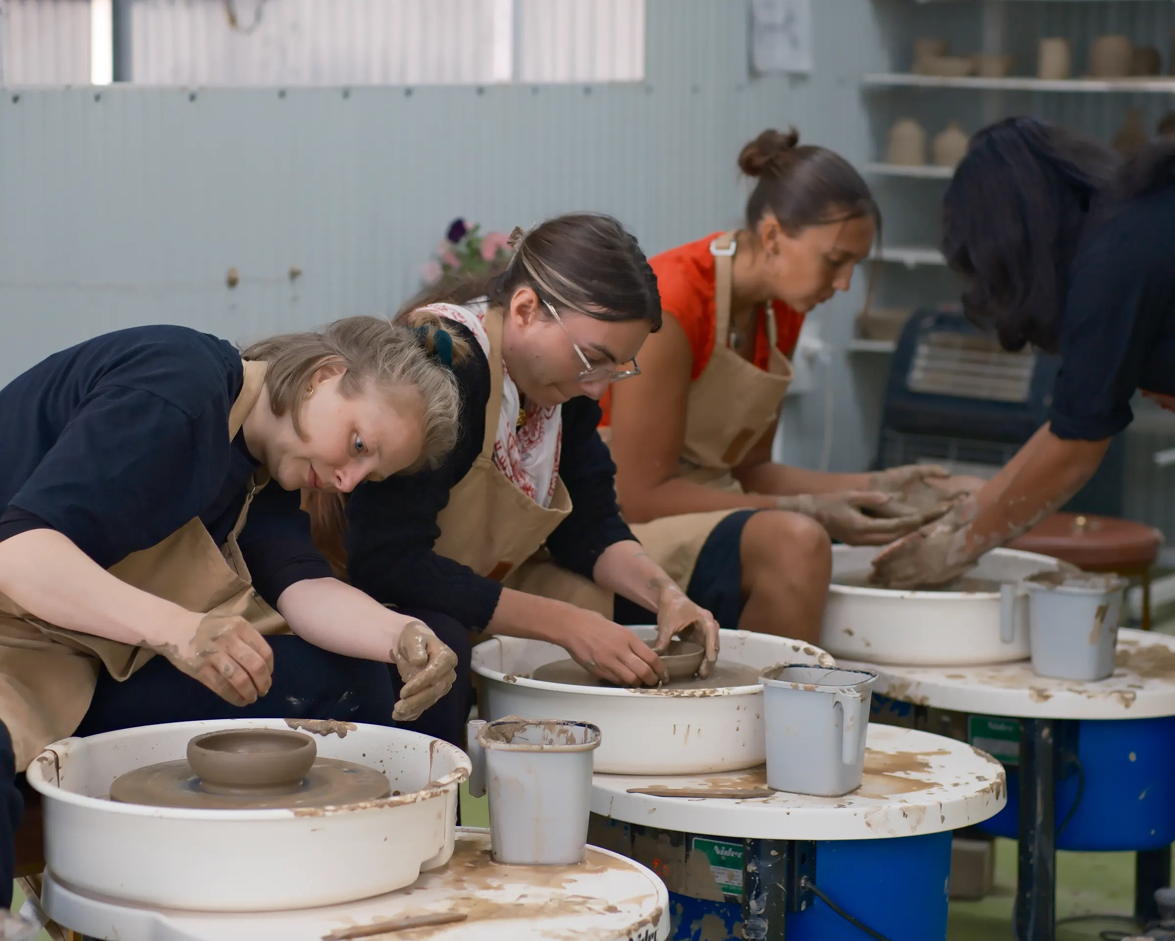 Ceramic artists practicing wheel throwing during the Dharamkot Studio instructor residency.
